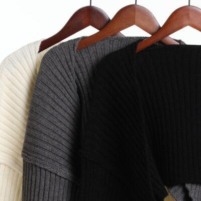 Three ribbed knit sweaters on hangers.